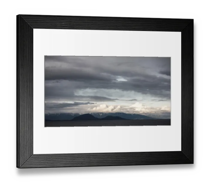 Framed Print : Clouds hover over distant mountains and sea in a moody landscape as seen from a passenger ferry Framed Print : Clouds hover over distant mountains and sea in a moody landscape as seen from a passenger ferry