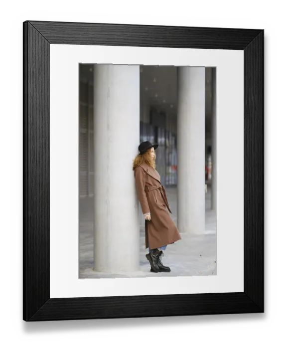 Framed Print : A woman leans against a concrete column in a city area