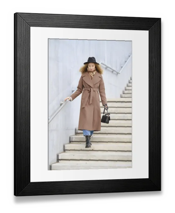 Framed Print : A woman with curly hair is walking down the stairs