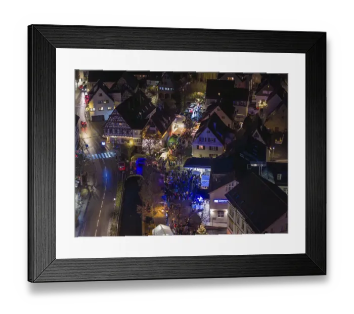 Framed Print : Aerial view of a Christmas market at night with a dense crowd and illuminated half-timbered houses