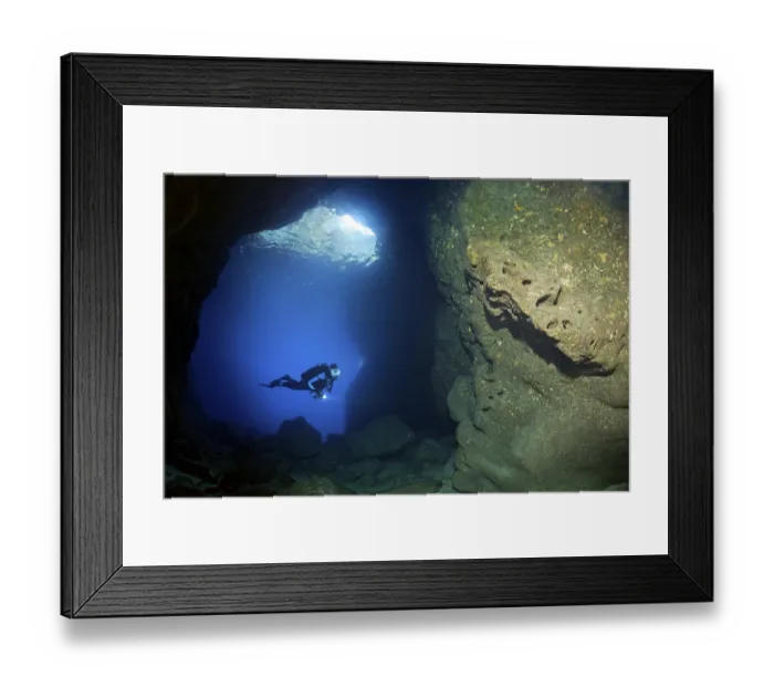 Framed Print : Diver with lamp in rocky cave, sparse growth Framed Print : Diver with lamp in rocky cave, sparse growth