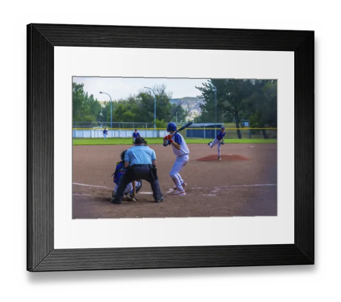 Framed Print : Teenage baseball batter waiting for the pitch while the pitcher is throwing the ball during a sunny summer game
