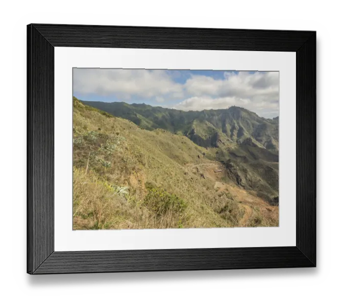 Framed Print : Wide mountain landscape with green vegetation under a cloudy sky Framed Print : Wide mountain landscape with green vegetation under a cloudy sky