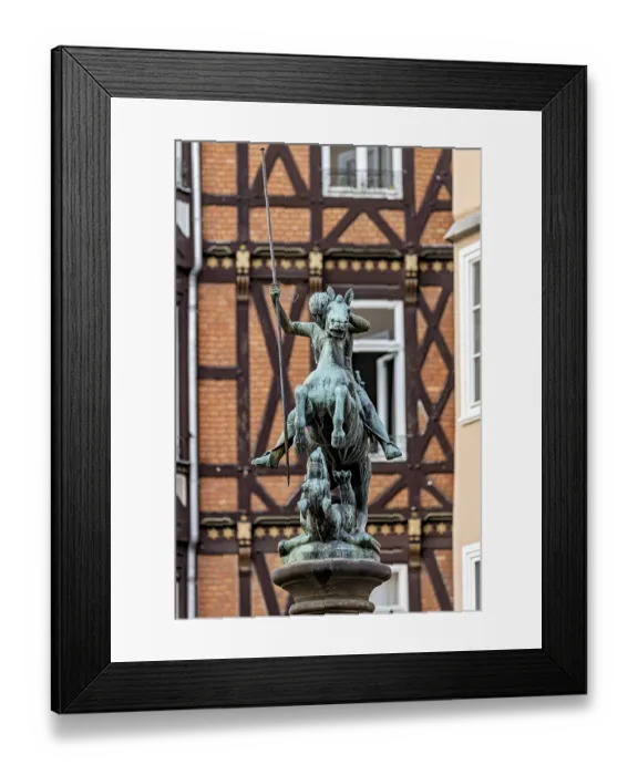 Framed Print : Bronze equestrian statue in front of half-timbered houses in urban surroundings Framed Print : Bronze equestrian statue in front of half-timbered houses in urban surroundings