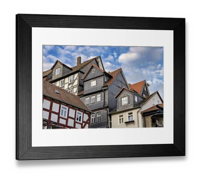 Framed Print : Traditional half-timbered houses with tiled roofs and cloudy skies