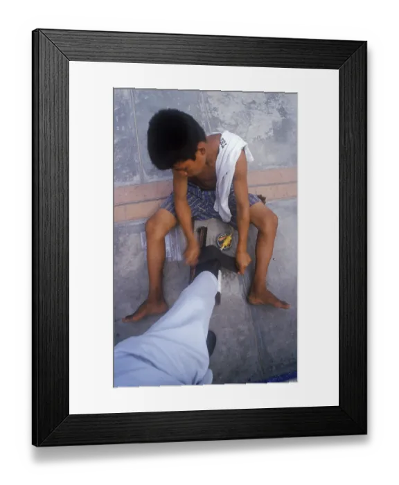 Framed Print : Young shoe cleaner working in Iquitos