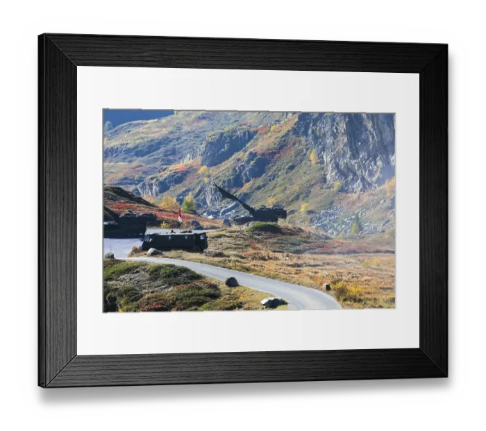 Framed Print : Tanks on a road through colorful autumnal hills in front of rocky mountains