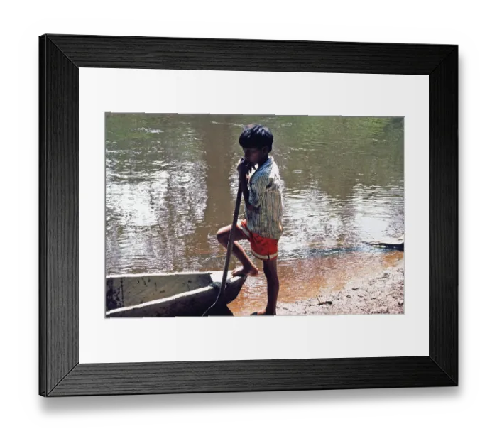 Framed Print : Little boy standing next to a boat Framed Print : Little boy standing next to a boat