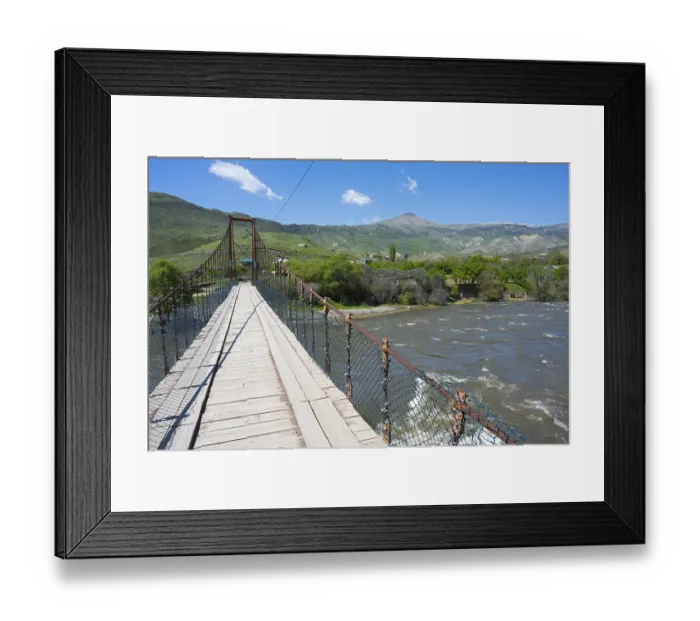 Framed Print : View of a swinging suspension bridge spanning a river Framed Print : View of a swinging suspension bridge spanning a river