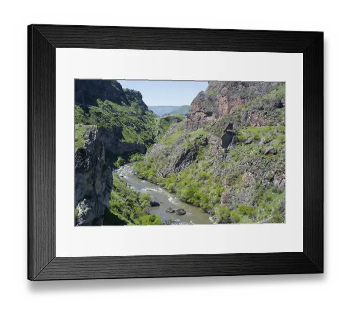 Framed Print : A river flows through a narrow green gorge with steep rocky slopes Framed Print : A river flows through a narrow green gorge with steep rocky slopes