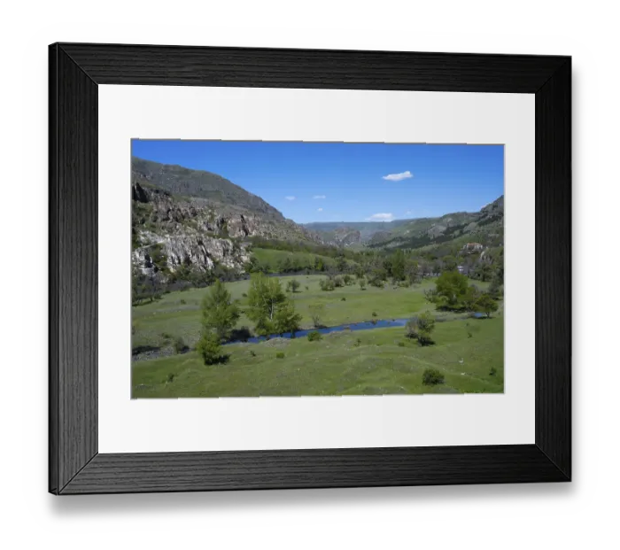 Framed Print : Extensive green valley with a small river and hill background Framed Print : Extensive green valley with a small river and hill background