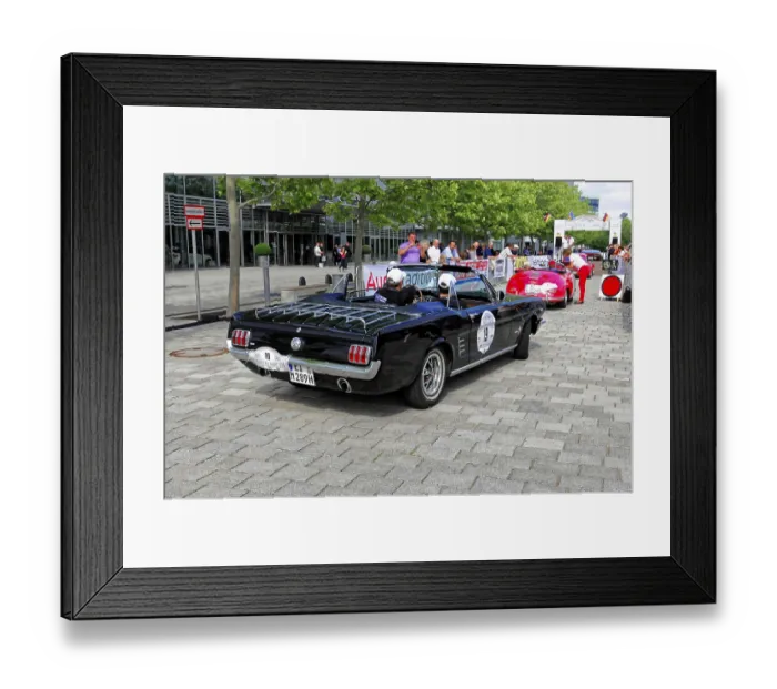 Framed Print : Black vintage convertible with racing stickers at a car event on a paved road