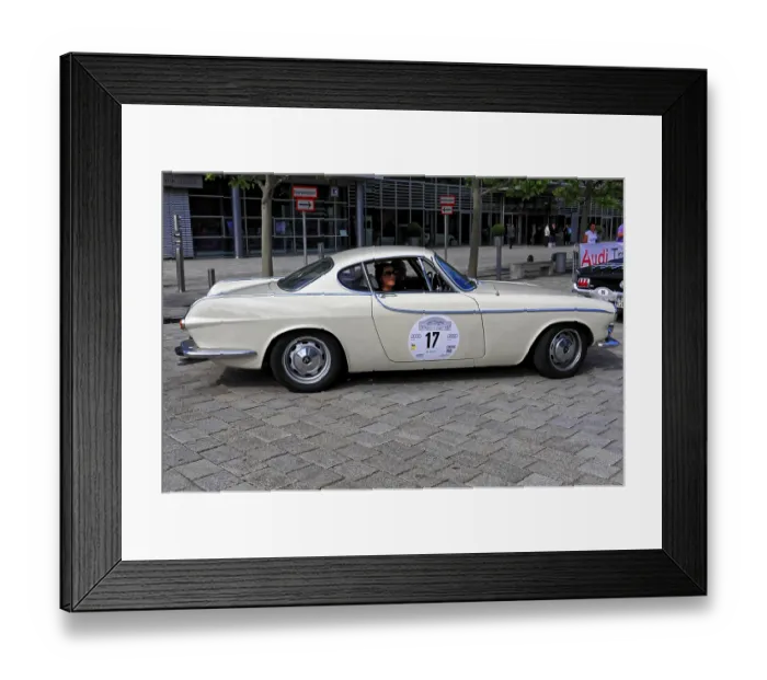 Framed Print : Cream-colored classic car with classic lines and drivers in an urban road environment