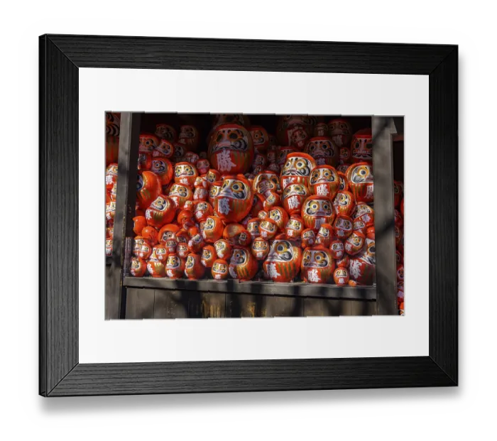 Framed Print : Lots of red Daruma dolls stacked in various sizes on a shelf in a Japanese temple