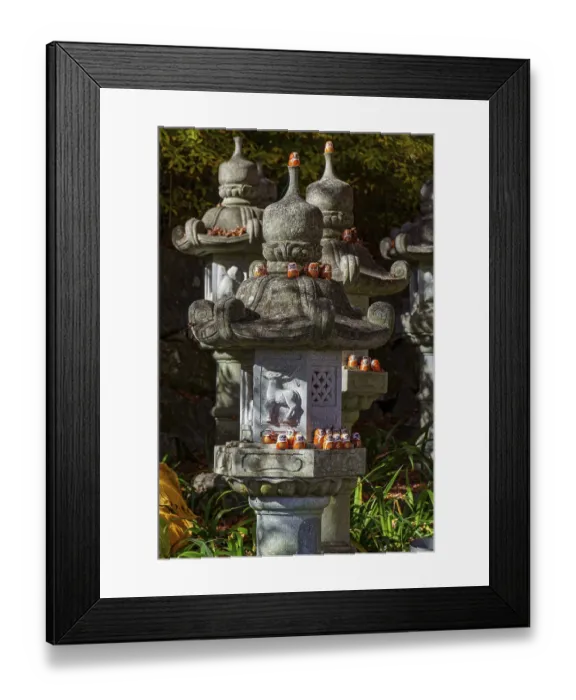 Framed Print : Stone lanterns decorated with small figures stand in a Japanese garden