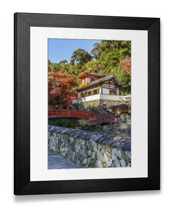 Framed Print : A traditional Japanese temple with red bridge and autumn foliage in a natural setting