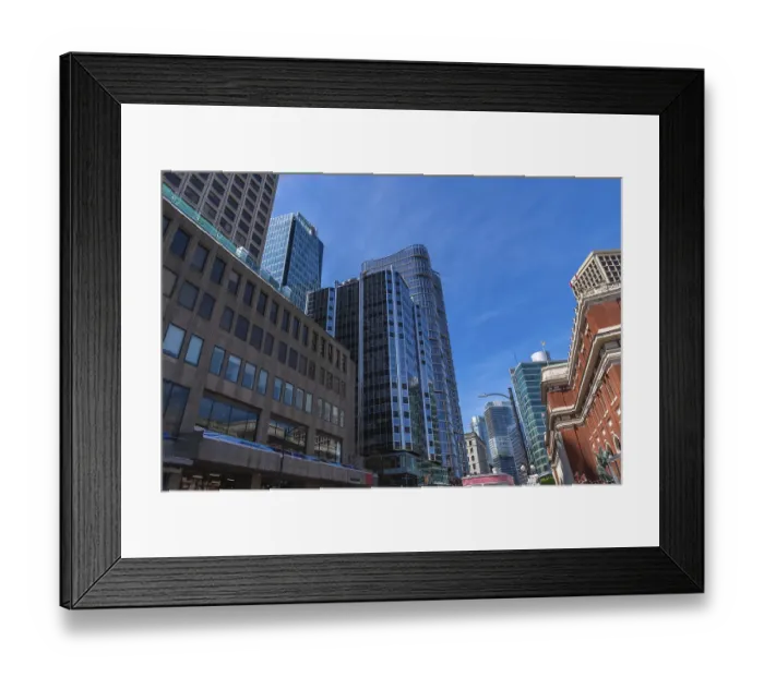 Framed Print : Modern glass skyscrapers and historical brick buildings stand tall against a vibrant blue sky Framed Print : Modern glass skyscrapers and historical brick buildings stand tall against a vibrant blue sky