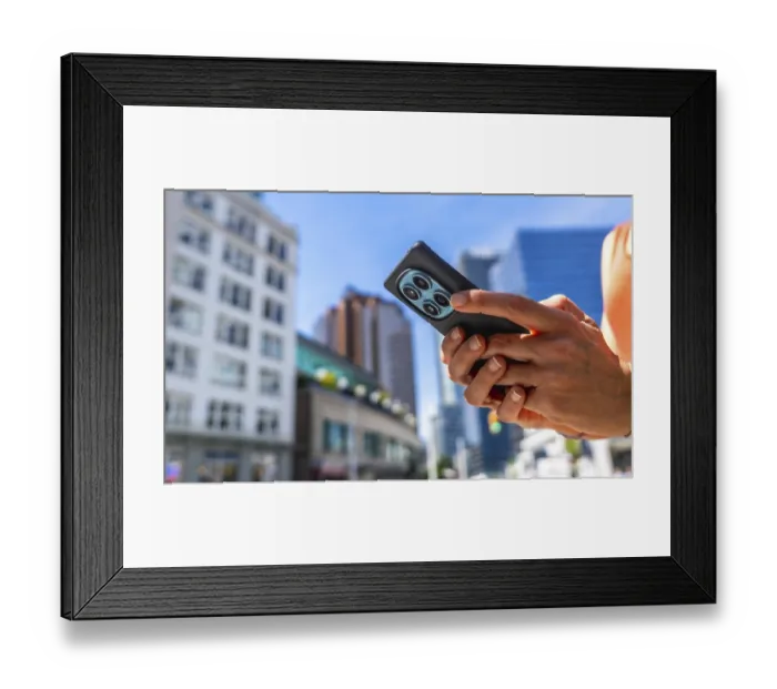 Framed Print : Close up of hands holding smartphone with multiple camera lenses