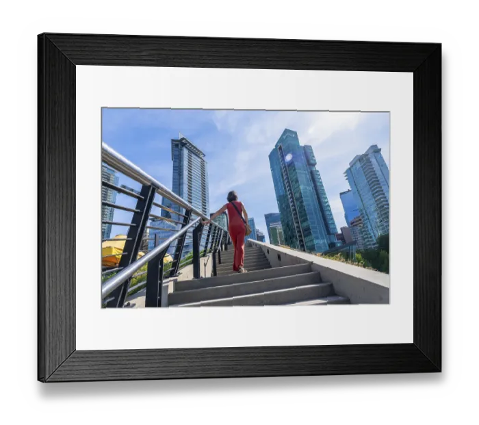 Framed Print : Tourist walking up stairs with skyscrapers and modern architecture in the background Framed Print : Tourist walking up stairs with skyscrapers and modern architecture in the background
