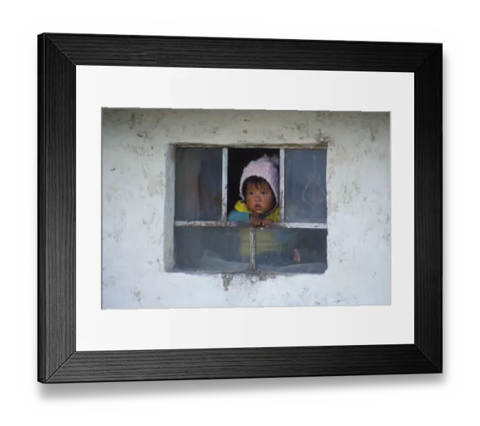 Framed Print : Little child looking out of a window near Cusco