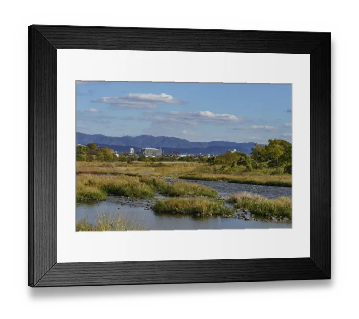 Framed Print : Wide river landscape with mountains in the background and clear blue sky