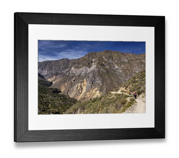 Framed Print : People hiking on a trail along a mountain edge