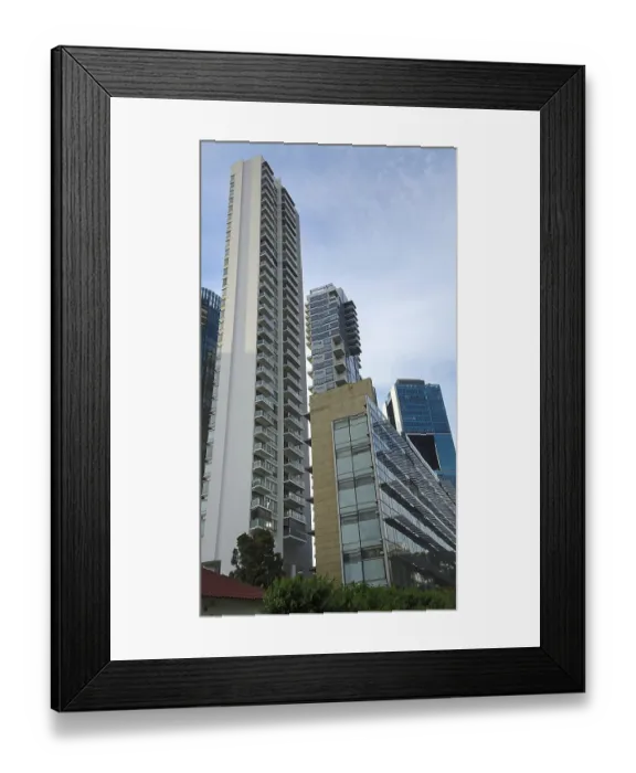 Framed Print : Dramatic perspective of high-rise buildings with glass facades standing out against the blue sky