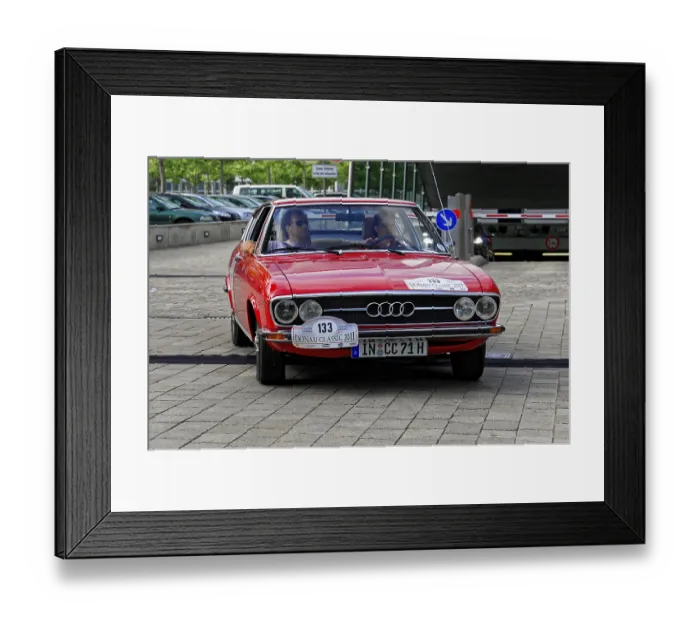 Framed Print : AUDI, A red vintage car drives on cobblestones with two people in the car