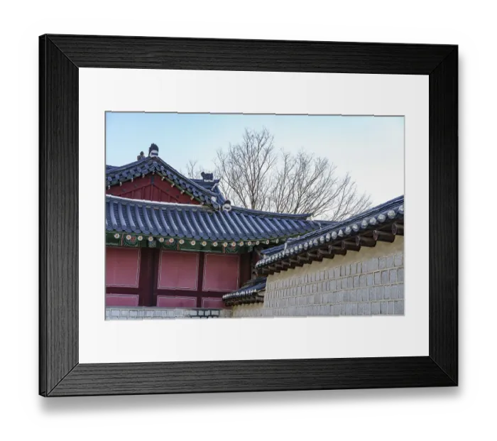 Framed Print : Traditional building architecture with tiled roofs and tree backdrop