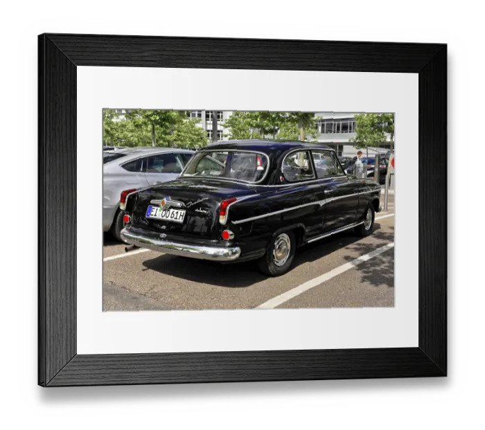 Framed Print : The rear view of a black classic car in a parking lot in sunny weather