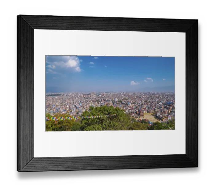 Framed Print : Wide view of a big city, colorful prayer flags in the foreground