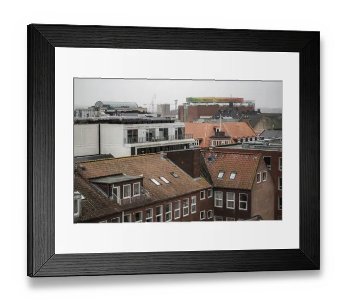 Framed Print : A mix of traditional and modern architecture in a cityscape featuring a colorful rooftop installation in Aarhus