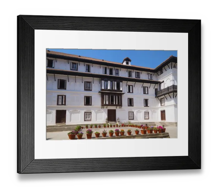 Framed Print : Historic building with numerous windows and decorative flower pots in front