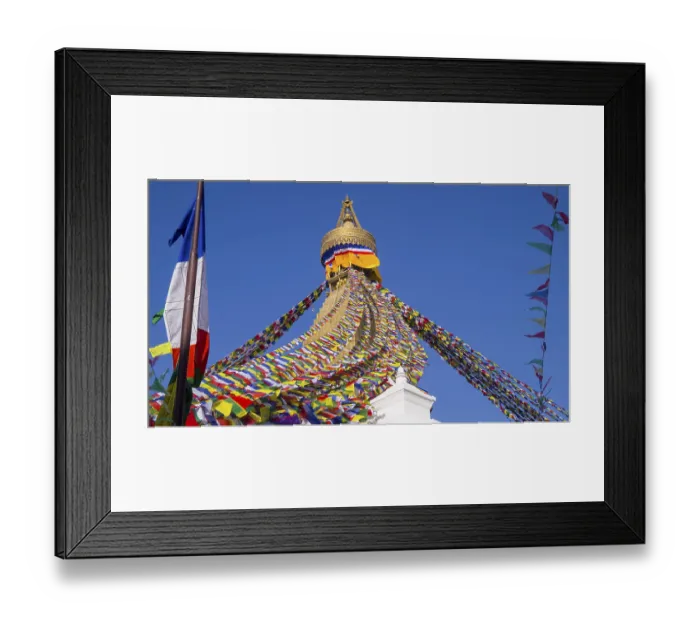 Framed Print : Colourful prayer flags surround the golden tip of a stupa