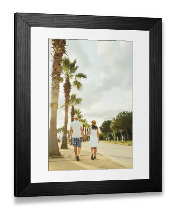 Framed Print : Young couple tourists walking hand in hand along Batumi promenade with palm trees and seaside view on sunrise