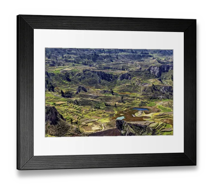 Framed Print : Landscape with terraced fields surrounded by mountains and a small lake under cloudy sky Framed Print : Landscape with terraced fields surrounded by mountains and a small lake under cloudy sky