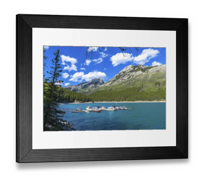 Framed Print : Many motorboats are resting on the turquoise waters of lake minnewanka