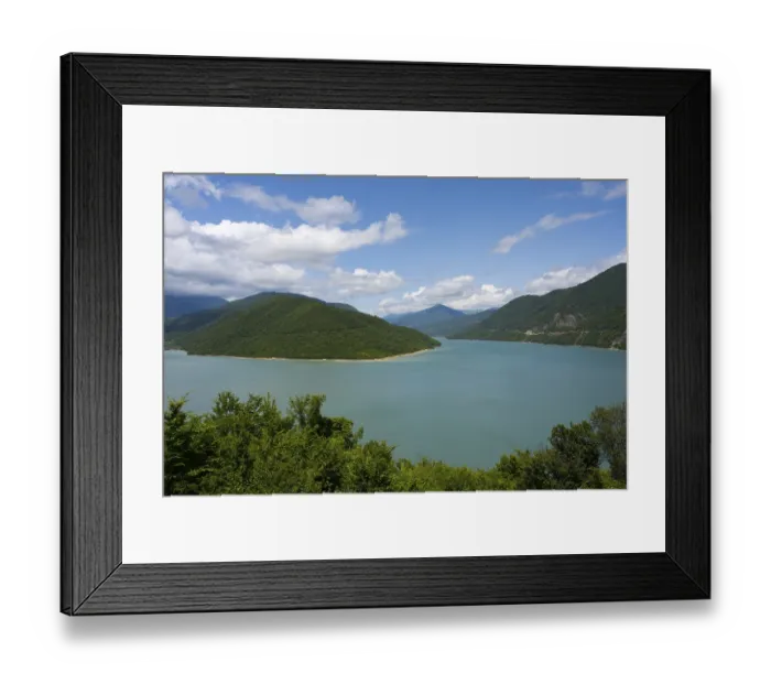 Framed Print : Idyllic landscape with a large lake surrounded by green mountains under a blue sky with clouds