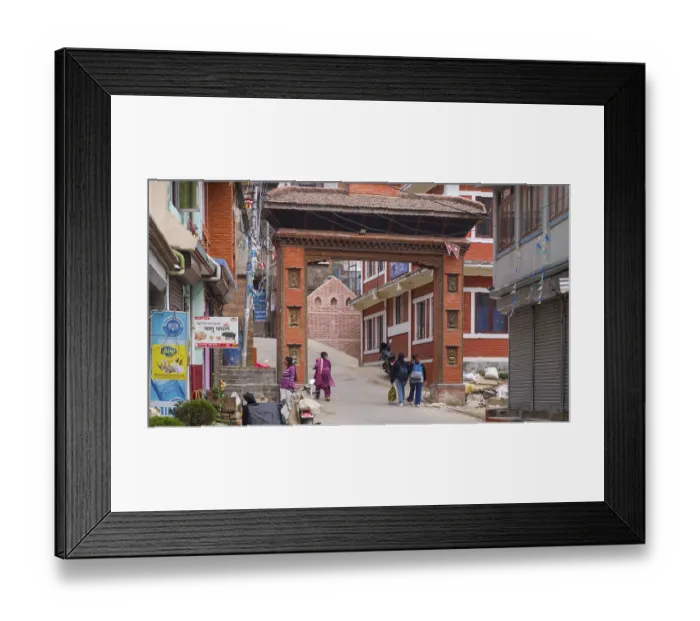 Framed Print : Traditional red brick gate with passers-by in a Nepalese city street
