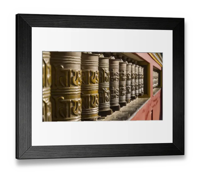 Framed Print : Artfully decorated metal prayer wheels in a row in a monastic setting with intensive play of light and shadow