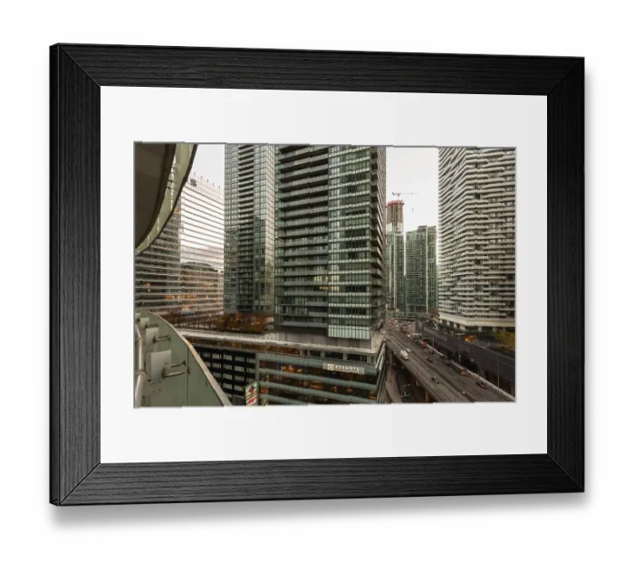 Framed Print : Dense urban skyline featuring towering modern skyscrapers and a busy roadway below in Toronto Framed Print : Dense urban skyline featuring towering modern skyscrapers and a busy roadway below in Toronto