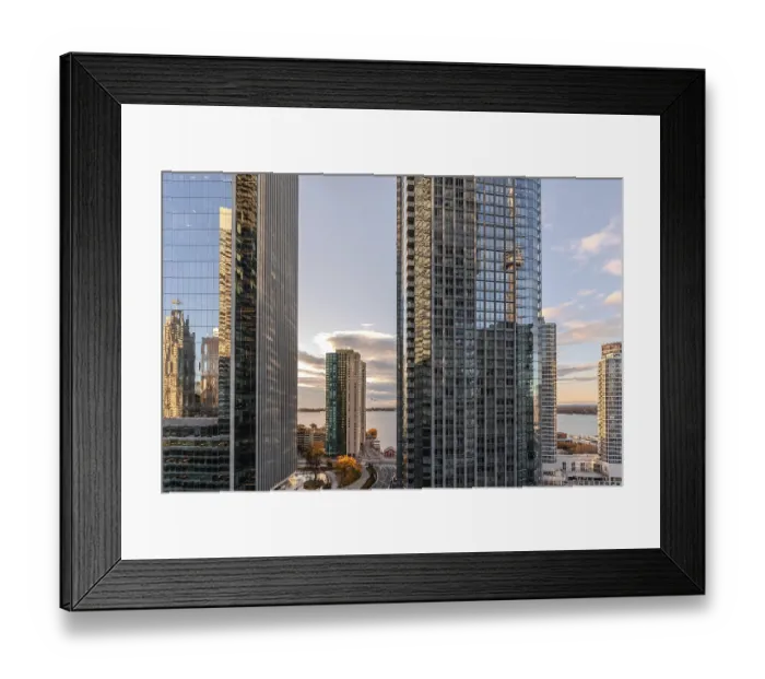 Framed Print : A vibrant cityscape with glass skyscrapers reflecting the sunset and a scenic view