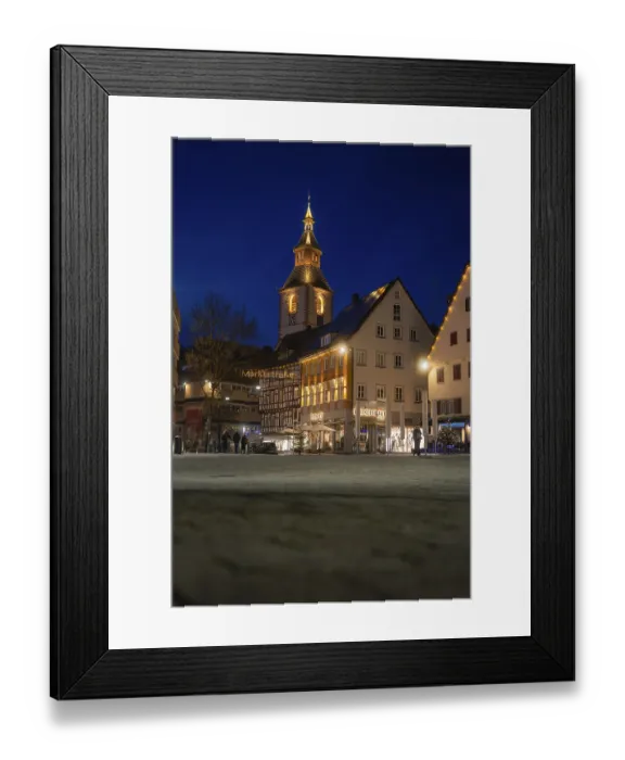 Framed Print : View of illuminated church tower and historic buildings in the evening darkness of the city
