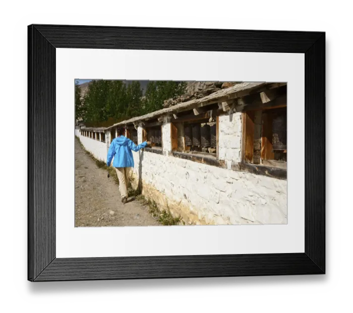 Framed Print : Girl turns prayer wheel in Muktinath temple, Nepal