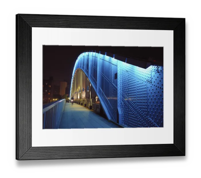 Framed Print : Pedestrian way along the metallic arc structure of Eitai bridge with moving bicycle by night time in Tokyo Japan