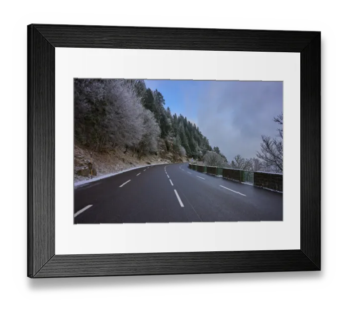 Framed Print : Snowy road snaking through a wintery forest with frost-covered trees Framed Print : Snowy road snaking through a wintery forest with frost-covered trees