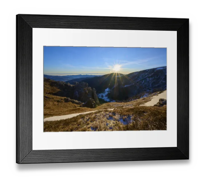 Framed Print : Sunrise over a snow-covered valley surrounded by mountains and rocks Framed Print : Sunrise over a snow-covered valley surrounded by mountains and rocks