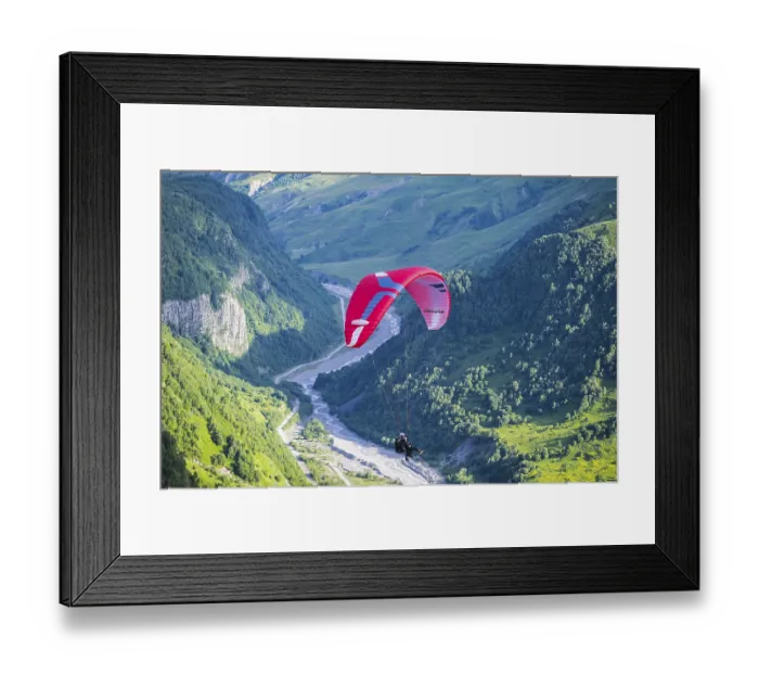 Framed Print : A paraglider floats over a narrow