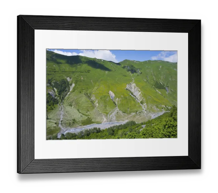 Framed Print : Green mountains and valleys with flowing river under blue sky
