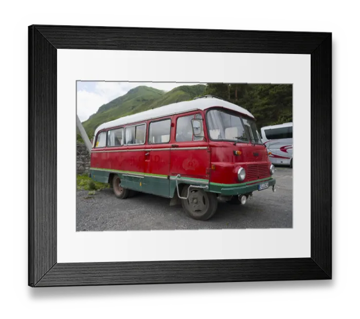 Framed Print : Old nostalgic bus in red with green accent on a parking lot in a mountainous landscape Framed Print : Old nostalgic bus in red with green accent on a parking lot in a mountainous landscape